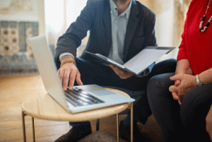 Man and woman discussing something at laptop